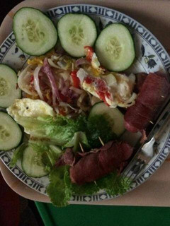 A picture of Fried egg with sausage,cucumber and lettuce.