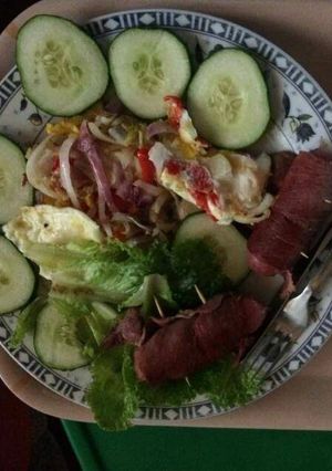 A picture of Fried egg with sausage,cucumber and lettuce.