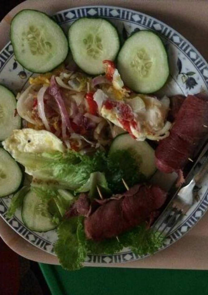A picture of Fried egg with sausage,cucumber and lettuce.