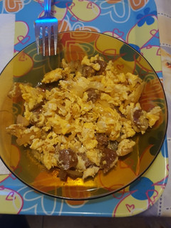 Una foto de Huevos rotos con cebolla y chorizo