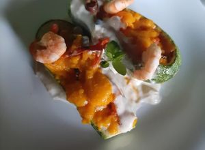 Una foto de Calabacita española rellena de camarón, bañada en salsa bechamel