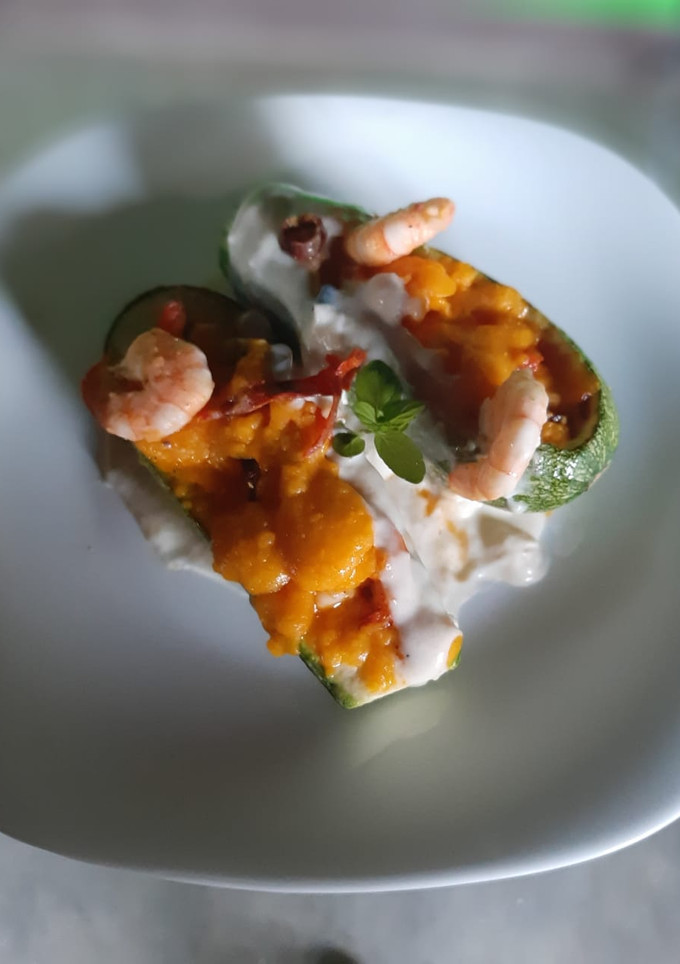 Una foto de Calabacita española rellena de camarón, bañada en salsa bechamel