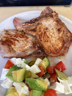 Una foto de Chuleta de cerdo con aguacate, tomate y queso