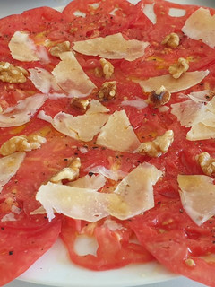 Una foto de Carpaccio de tomate con lascas de queso ahumado y nueces