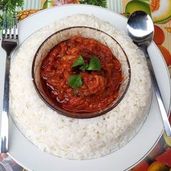 A picture of Boiled rice and tomato stew.