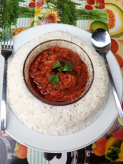 A picture of Boiled rice and tomato stew.