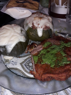 Una foto de Zapallitos rellenos de carne picada y salsa blanca acompañadas