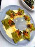 Ravioles de albahaca con relleno de queso crema, pepperoni y pistachos en salsa de queso parmesano
