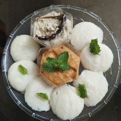 A picture of Baby idlis with coconut chutney and onion tomato chutney.