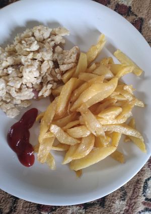 A picture of Chips with scrambled egg and ketchup.