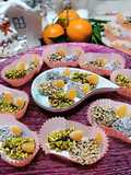 Spicchi di clementine ricoperti di cioccolato fondente e granelle varie