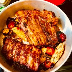 A picture of Bbq Spare Ribs with potatoes And Cherry Tomatoes.