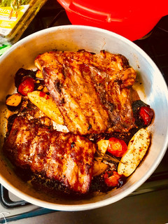 A picture of Bbq Spare Ribs with potatoes And Cherry Tomatoes.