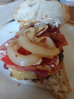Una foto de Hamburguesa de Angus con bacon, queso, tomate, cebolla y pan cristal