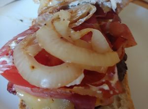 Una foto de Hamburguesa de Angus con bacon, queso, tomate, cebolla y pan cristal