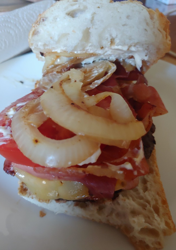 Una foto de Hamburguesa de Angus con bacon, queso, tomate, cebolla y pan cristal