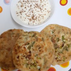 A picture of Paneer Paratha with Spring Onions.