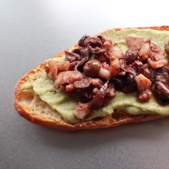 A picture of Bruschettone crema di zucchine con calamari e olive.