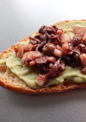 A picture of Bruschettone crema di zucchine con calamari e olive.