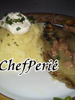Una foto de Chuletas de cerdo en crema de hongos y chorizo con puré de papas