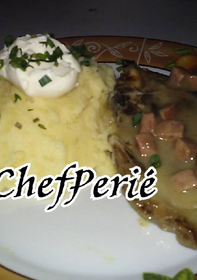 Una foto de Chuletas de cerdo en crema de hongos y chorizo con puré de papas