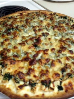 A picture of Alfredo chicken spinach pizza.