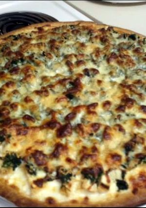 A picture of Alfredo chicken spinach pizza.