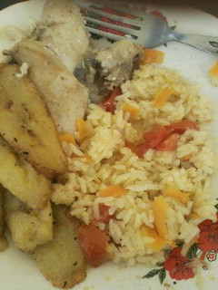 Una foto de Pollo al ajo con arroz con tomate y plátano maduro