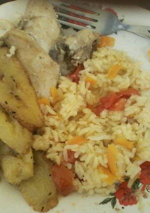 Una foto de Pollo al ajo con arroz con tomate y plátano maduro