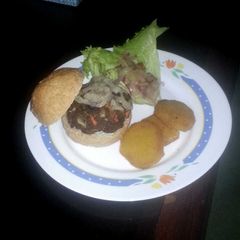 A picture of Beef patty with fried sweet potatoes and salad.