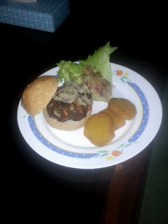 A picture of Beef patty with fried sweet potatoes and salad.
