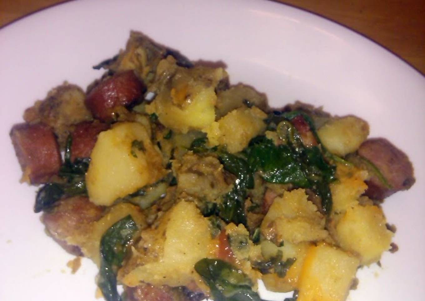 Dinner in a frying pan with sausages and potatoes.