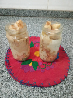 Una foto de Cheesecake en frascos.De dulce de leche, banana y canelay de café