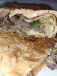 Una foto de "Calzone" de huevo con ajos tiernos y setas