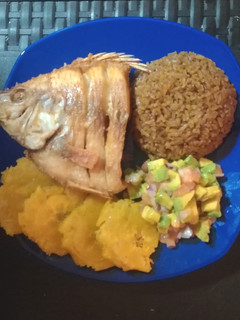 Una foto de Pescado frito acompañado con arroz con coco-patacones y ensalada de aguacate
