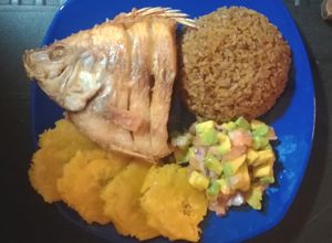Una foto de Pescado frito acompañado con arroz con coco-patacones y ensalada de aguacate