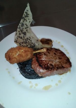 Una foto de Atún con risotto negro, anca de rana y crocante de arroz
