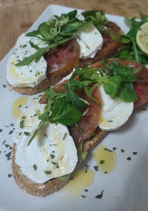 Una foto de Tosta con aguacate tomate y queso de cabra
