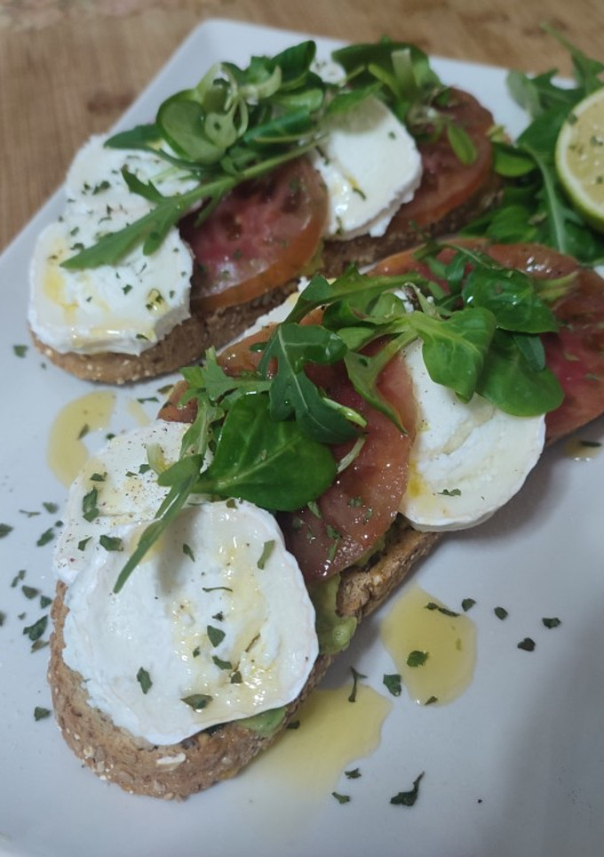 Una foto de Tosta con aguacate tomate y queso de cabra