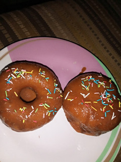 A picture of Doughnut wit melted chocolate and sprinkles.
