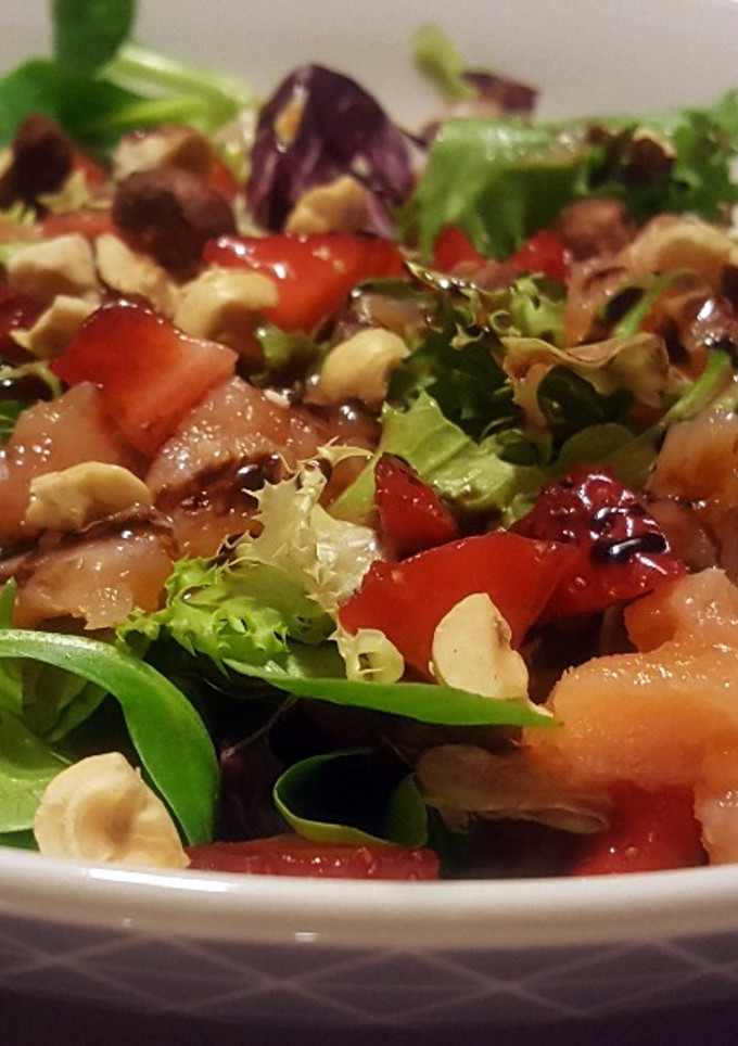 Una foto de Ensalada variada con salmón, fresas y avellanas