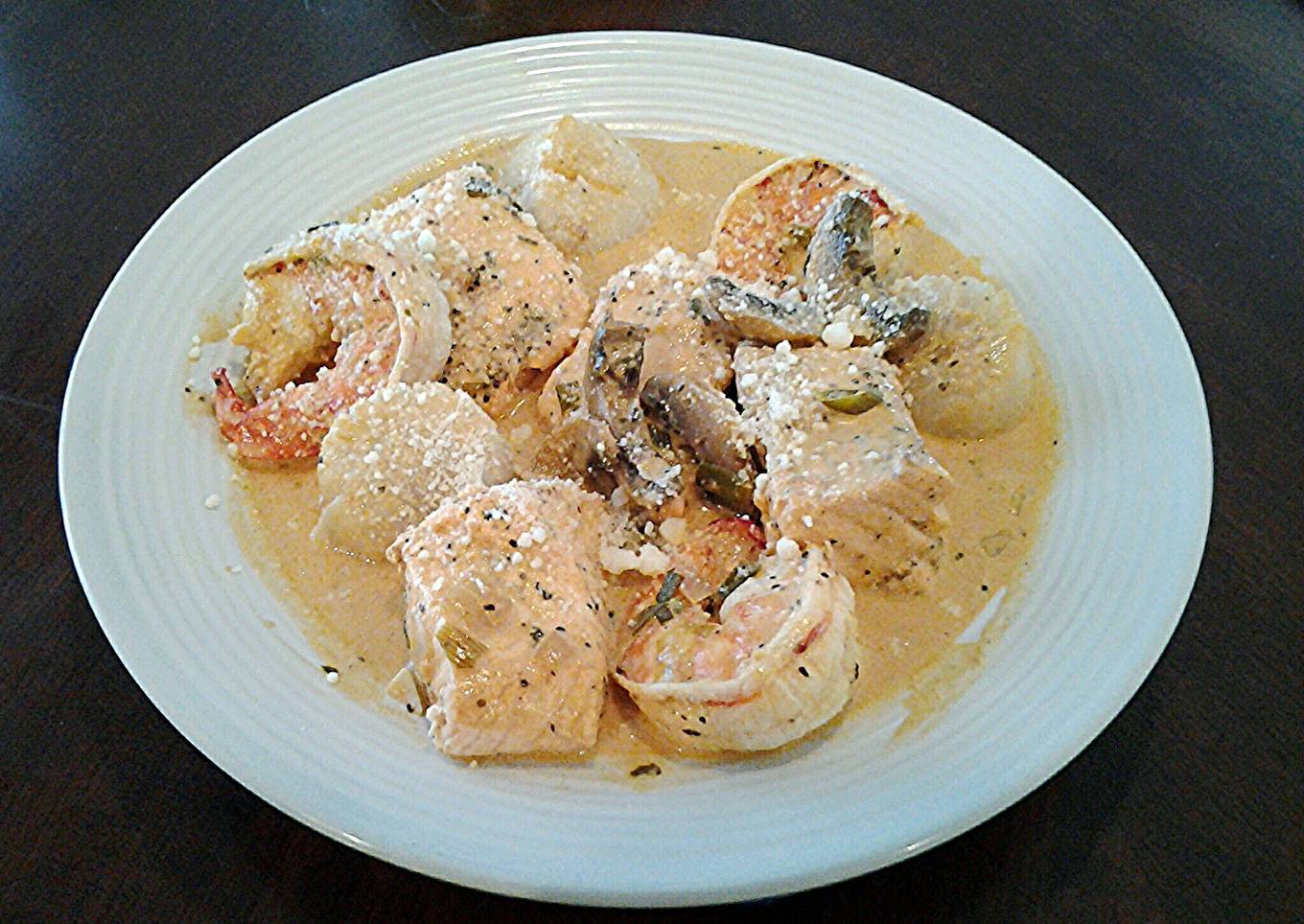 Salmon, Shrimp and Scallops poached in a Tomato Cream Broth