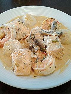 A picture of Salmon, Shrimp and Scallops poached in a Tomato Cream Broth.