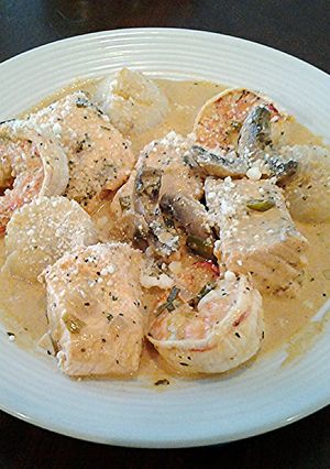 A picture of Salmon, Shrimp and Scallops poached in a Tomato Cream Broth.