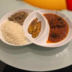 A picture of Rice and beans with plantain and stew.