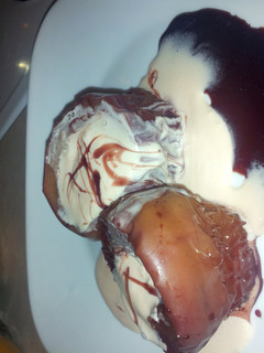 A picture of red wine poached apples with a honey cherry cheese cake maskotto cream.