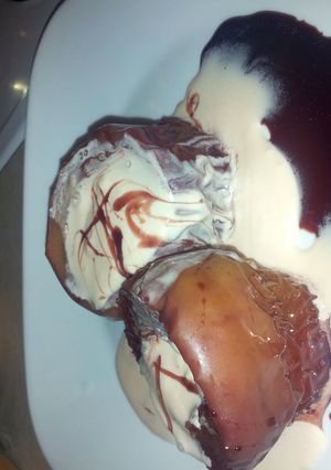 A picture of red wine poached apples with a honey cherry cheese cake maskotto cream.