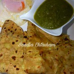 A picture of Aloo ka paratha with green chutney.