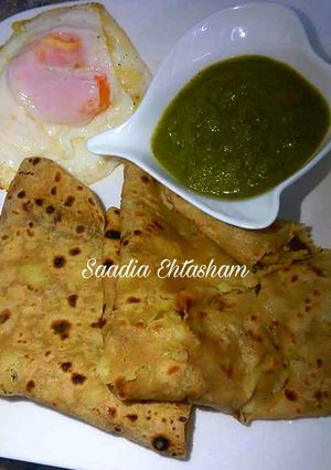 A picture of Aloo ka paratha with green chutney.