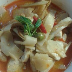 A picture of red curry chickens with pickled bamboo.